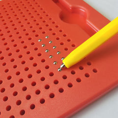 Red pegboard with yellow tool and small metallic objects on a white background