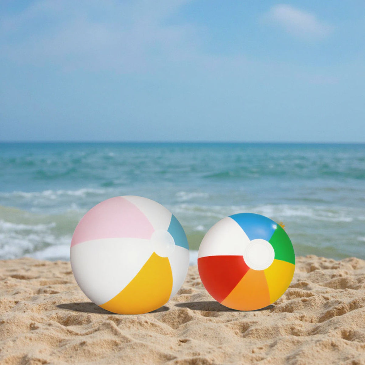 Two colorful beach balls on a sandy beach with ocean in the background