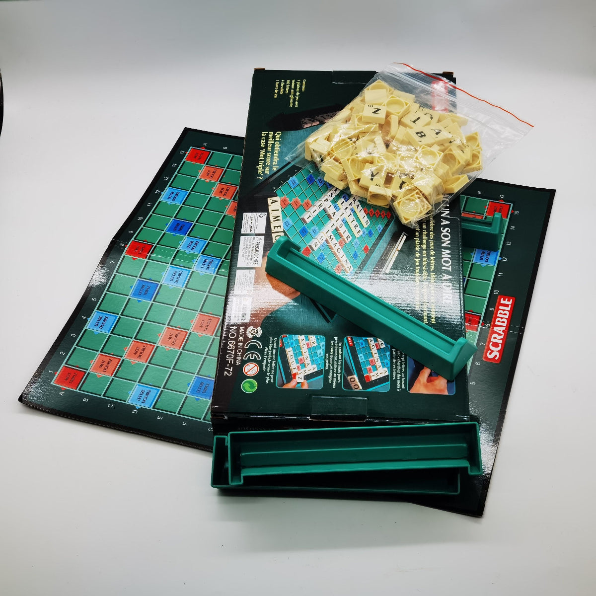 Scrabble board game set with tiles and packaging on a white surface