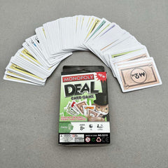 Monopoly Deal card game packaging with cards fanned out on a gray background